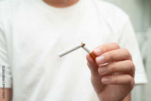 Quit smoking, Asian teenage man breaking destroy cigarette in hand.