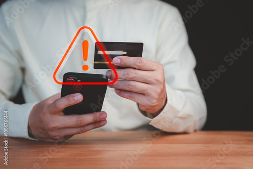 A person holding a credit card and smartphone with a red warning sign overlay, symbolizing online scams, fraud, security risks, and financial caution in digital transactions.