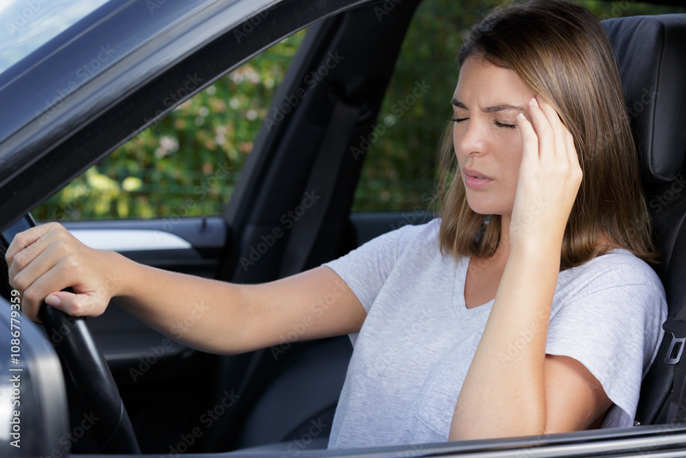 young lady suffering with a headache while driving her car young lady suffering with a headache while driving her car