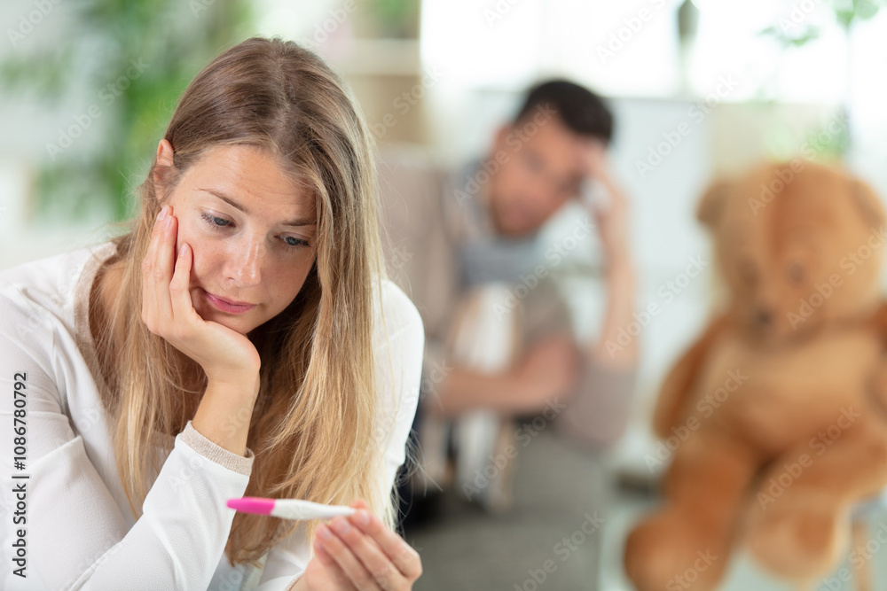 © auremar - sad young woman holding pregnancy test feeling hopeless