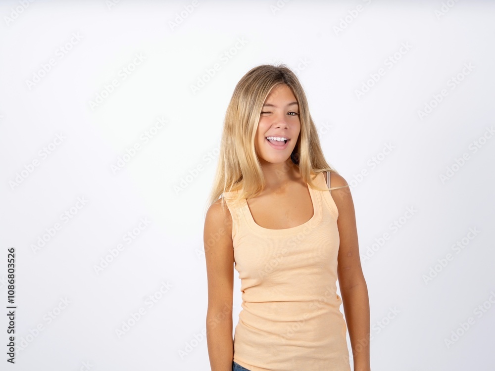 Beautiful teen girl wearing sleeveless t-shirt winking looking at the camera with sexy expression, cheerful and happy face. Beautiful teen girl wearing sleeveless t-shirt winking looking at the camera with sexy expression, cheerful and happy face.