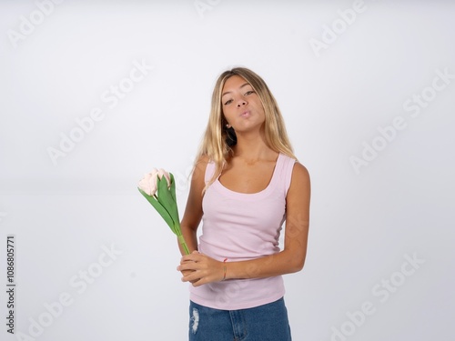 Shot of pleasant looking Beautiful teen girl wearing sleeveless t-shirt , pouts lips, looks at camera, Human facial expressions photo