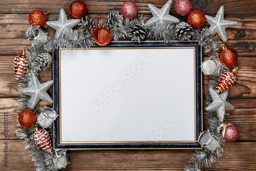 Frame with space for a copy of your images as a keepsake or a greeting text, richly decorated with silver-toned Christmas decorations such as pine cones, stars, drums, ball and garland