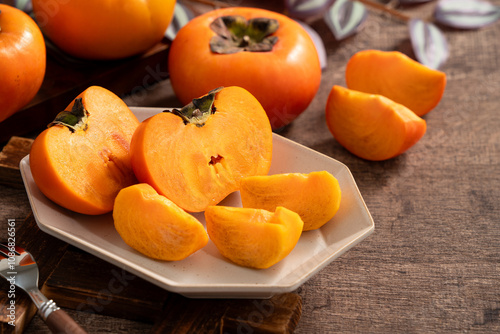 Fresh ripe persimmon fruit on wooden table background.