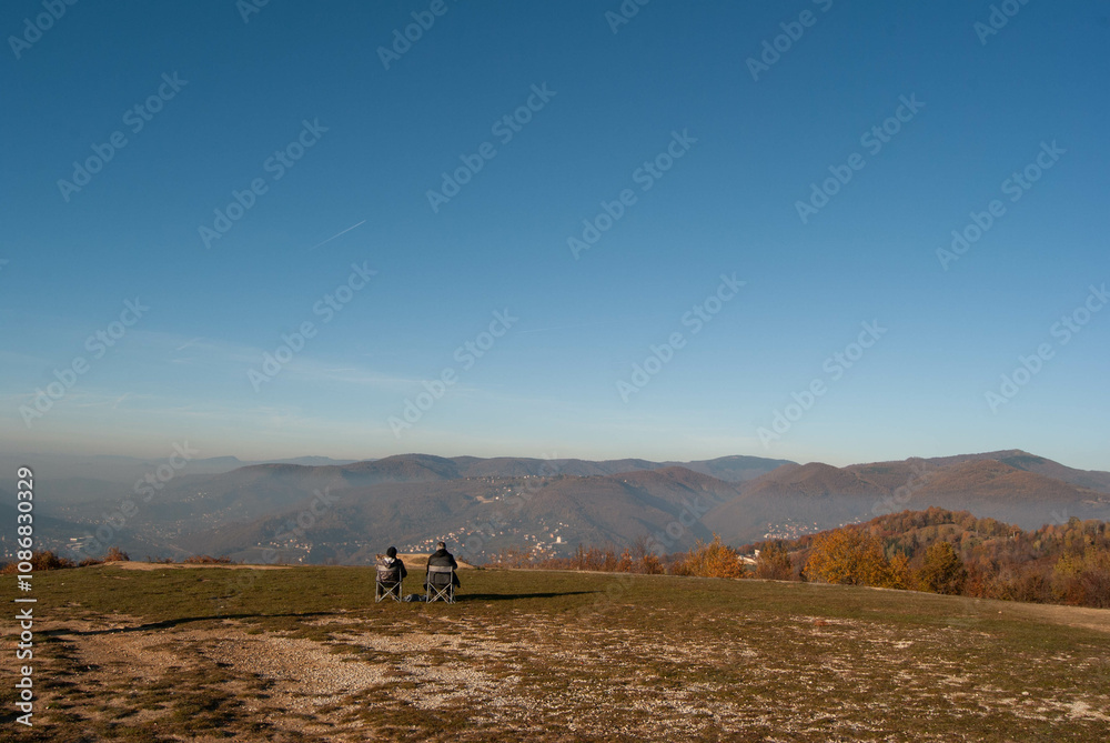 Seniors relaxing in folding chairs, surrounded by nature on a sunny hillside, capturing a moment of outdoor joy. Seniors relaxing in folding chairs, surrounded by nature on a sunny hillside, capturing a moment of outdoor joy.
