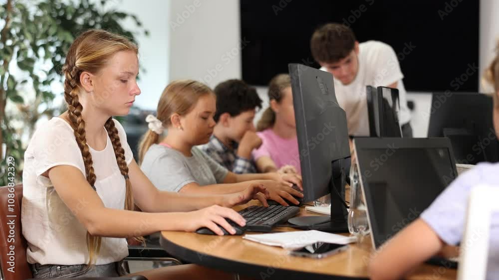 Curious underage girl engaged in IT training during computer courses for children Curious underage girl engaged in IT training during computer courses for children