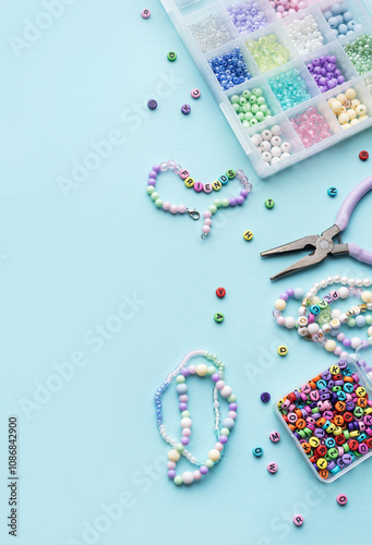 Foto Colorful beads and pliers creating friendship bracelets on blue background