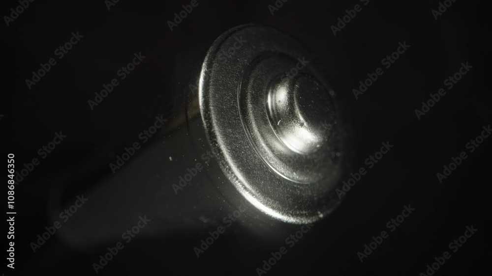 close-up of the same metallic battery, with focus on the bottom cap texture against a dark background. Highlights durability and refined metallic features. close-up of the same metallic battery, with focus on the bottom cap texture against a dark background. Highlights durability and refined metallic features.