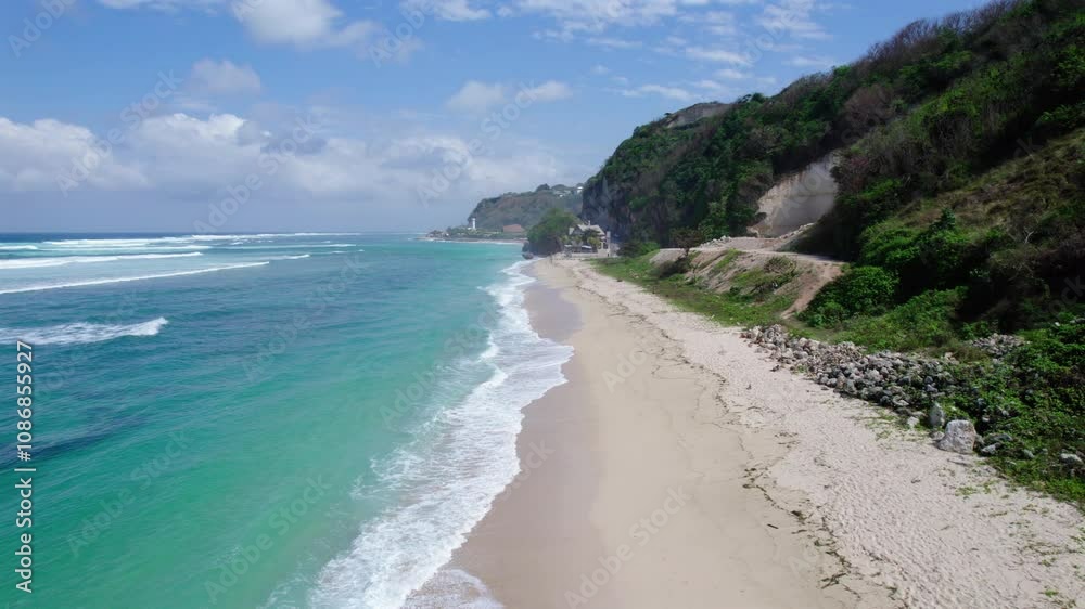 Drone travels along white sand beach in Bali, Indonesia