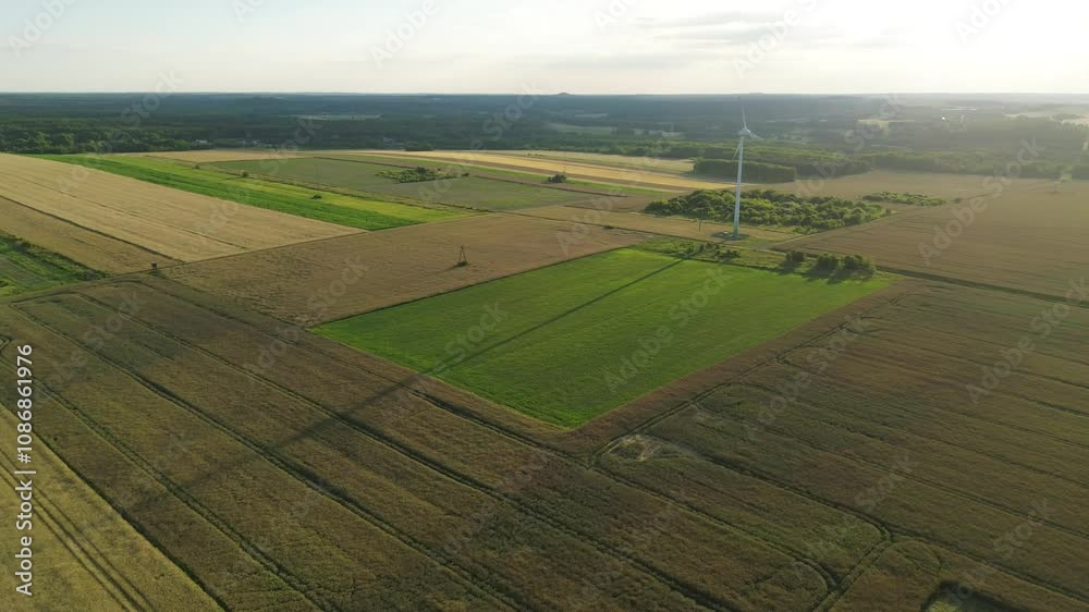 Wind turbine generating clean energy in rural landscape at sunset Wind turbine generating clean energy in rural landscape at sunset