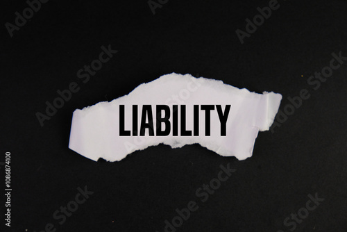 white torn paper with text of LIABILITY on black background as an economy concept.  photo