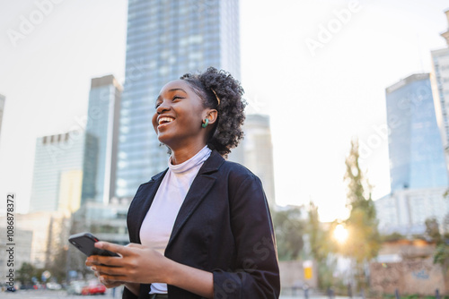 Portrait of a young woman using mobile phone in city
