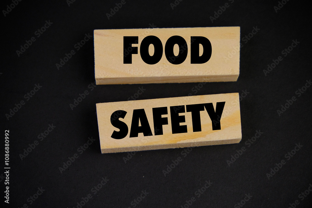 Wooden block form the word FOOD SAFETY on black background. Medical healthcare concept. Wooden block form the word FOOD SAFETY on black background. Medical healthcare concept.