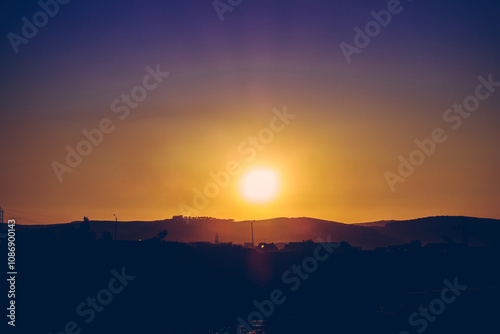 Captivating sunrise over silhouetted hills with vibrant colors in the sky.