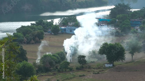 Village view at Chinyalisaur by the Bhagirathi River, stubble burning with smoke causing pollution in agricultural fields. photo