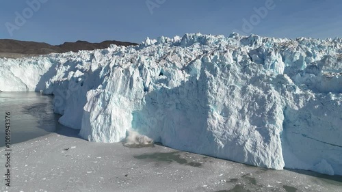 Impressive calving of ice at Eqi Glacier in Greenland during expedition. Eqip Sermia is one of the most frequently calving glaciers. photo