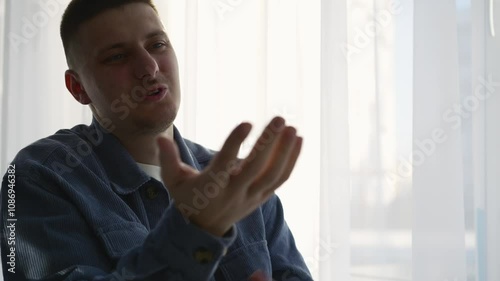 Serious man talking about business.
A man is talking and gesticulating with his hands.
Hand gestures during a conversation.
A man in a blue shirt communicates with his interlocutor
