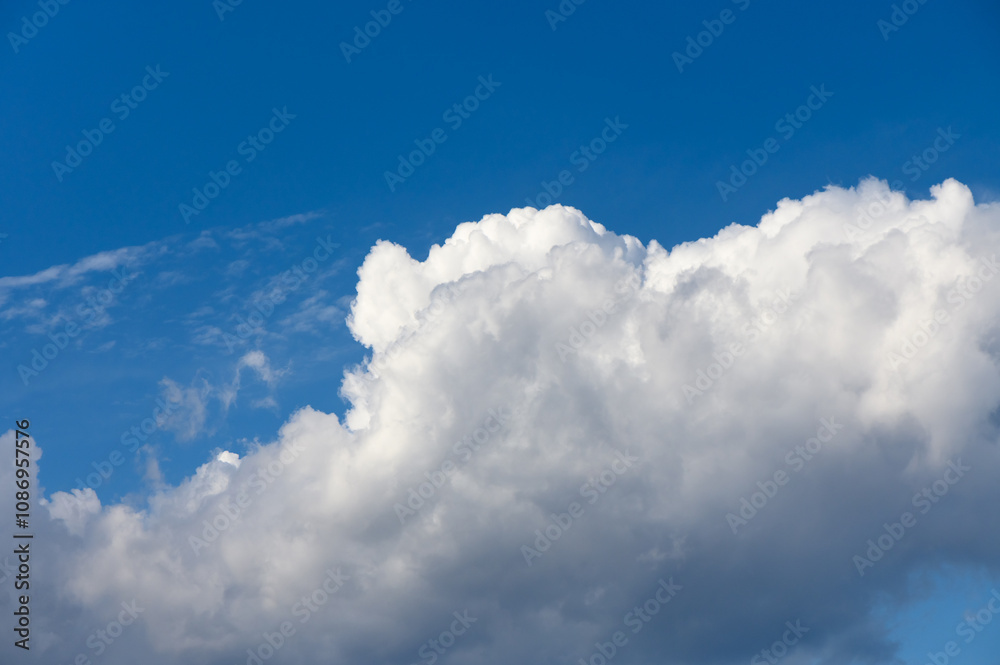 Majestic white clouds billow against a vibrant blue sky during a warm afternoon in summer Majestic white clouds billow against a vibrant blue sky during a warm afternoon in summer