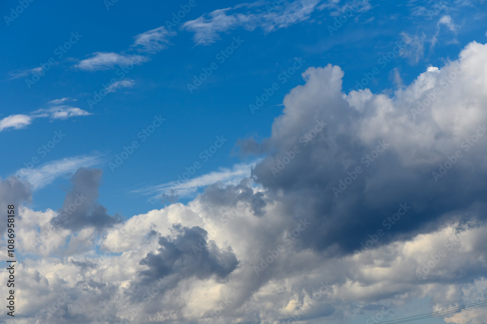A stunning display of clouds dancing in the vibrant blue sky during a calm afternoon A stunning display of clouds dancing in the vibrant blue sky during a calm afternoon