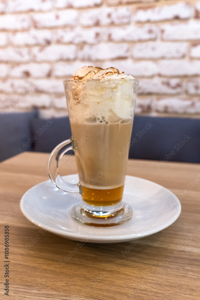 Gingerbread latte in a transparent glass cup. The creamy foam is topped with hints of cinnamon and grated nutmeg. Reflecting warm light, the drink evokes a sense of festive coziness, winter evenings. Gingerbread latte in a transparent glass cup. The creamy foam is topped with hints of cinnamon and grated nutmeg. Reflecting warm light, the drink evokes a sense of festive coziness, winter evenings.