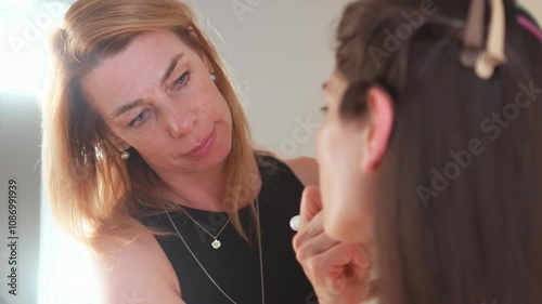 Wallpaper Mural Makeup artist carefully applies foundation to a client face in a well-lit studio. Environment is professional, enhancing the transformation process while focusing on details. Torontodigital.ca