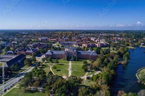 Aerial view of a sprawling university campus with brick buildings, lush green spaces, and a serene lake.