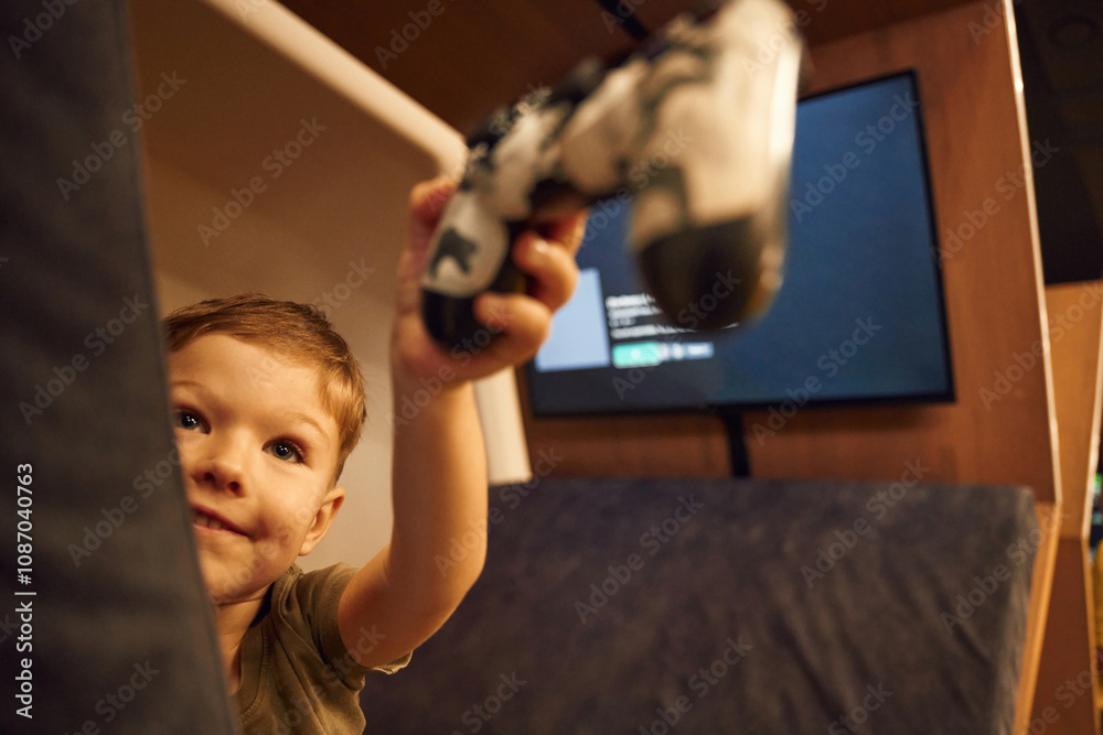 Boy is playing console game, holding joystick controller Boy is playing console game, holding joystick controller