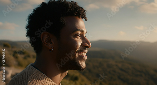 A smiling man wearing a small hoop earring for lifestyle and having short hair