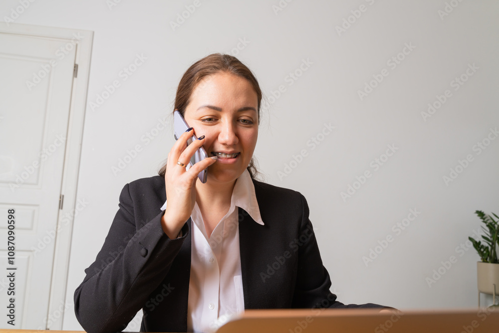 Young businesswoman with braces looks at her laptop screen. Young businesswoman with braces looks at her laptop screen.