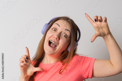 Modern woman smiling with braces on her teeth and listening to music photo