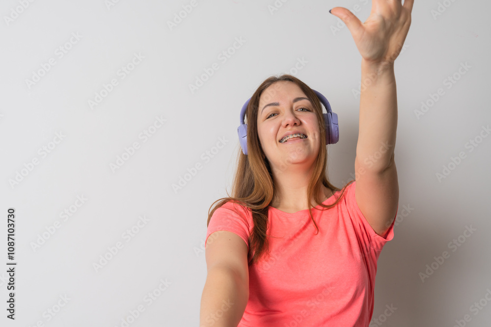 Modern woman smiling with braces on her teeth and listening to music Modern woman smiling with braces on her teeth and listening to music