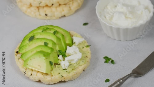 Crisp bread healthy snack with avocado, white cheese and thyme. Close-up.