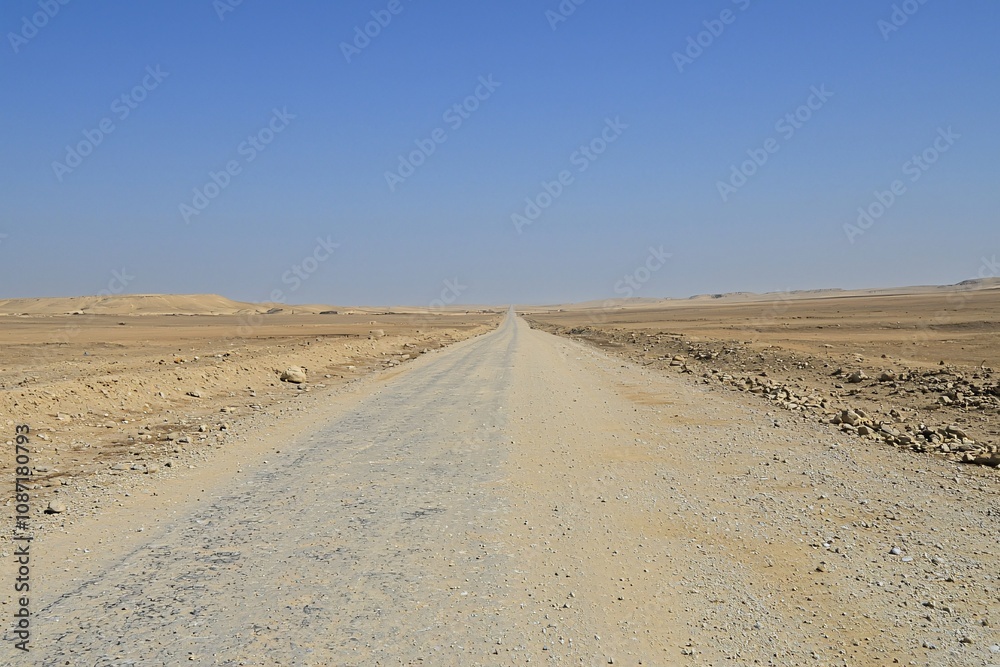 Desert Road Stretching to the Horizon under a Clear Blue Sky Desert Road Stretching to the Horizon under a Clear Blue Sky