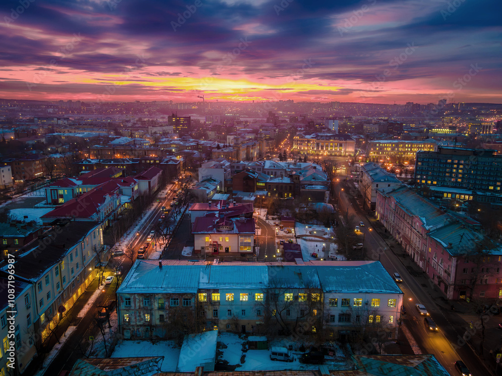 Fototapeta premium The evening panorama of Irkutsk city streets, with the colorful sunset and Russian architecture, in Russia. 