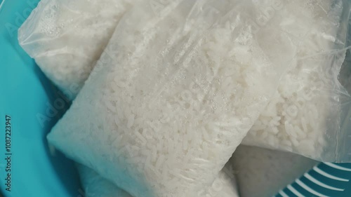 Cooked rice in a bag placed in a blue colander