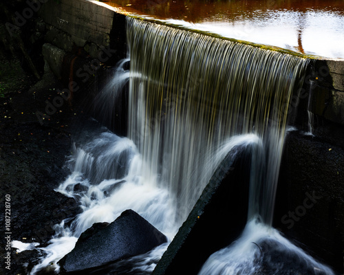 Fototapeta Naklejka Na Ścianę i Meble -  An artificial little waterfall cause by a dam