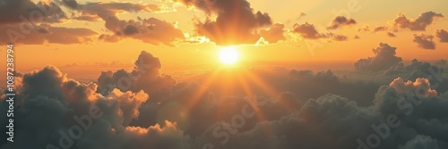 Above a sea of fluffy clouds, the sun descends, casting long golden rays through a partly cloudy sky