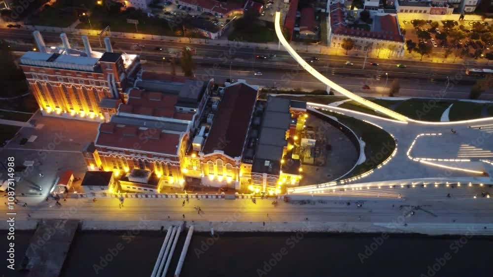 vista aérea de Belém, em Lisboa, com o icônico Rio Tejo ao fundo. Em destaque, vemos a histórica Torre de Belém situada próximo à margem do rio, com sua arquitetura manuelina característica. O Tejo é 