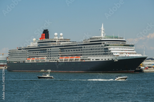 Luxury classic ocean liner cruiseship cruise ship Victoria in port of Helsinki, Finland with city skyline, marine traffic, archipelago island shores during summer Baltic cruising photo