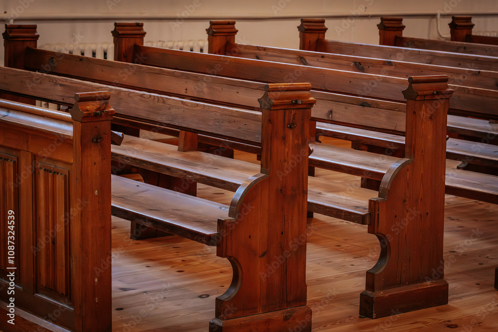Rows of beautifully crafted wooden pews inside a church, illuminated by warm, natural light. The polished wood grain and intricate details reflect a classic, timeless design Rows of beautifully crafted wooden pews inside a church, illuminated by warm, natural light. The polished wood grain and intricate details reflect a classic, timeless design