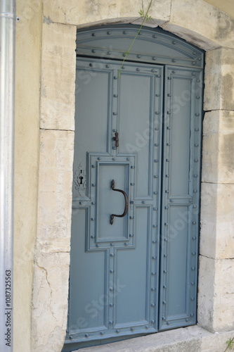 Closeup of a steel blue or dusty blue door in an old building located in the warm southern region of France