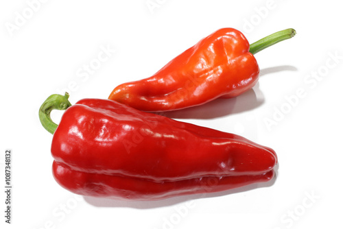 two red peppers are laying on a white surface.
