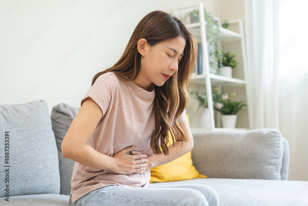Flatulence asian young woman intolerance hand in stomach ache, suffer from food poisoning, abdominal pain and colon problem, gastritis or diarrhoea when at home. Patient belly, abdomen or inflammation Flatulence asian young woman intolerance hand in stomach ache, suffer from food poisoning, abdominal pain and colon problem, gastritis or diarrhoea when at home. Patient belly, abdomen or inflammation