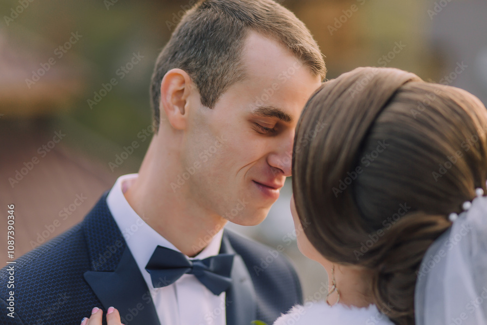 A man and woman are kissing each other's noses. The man is wearing a suit and tie A man and woman are kissing each other's noses. The man is wearing a suit and tie