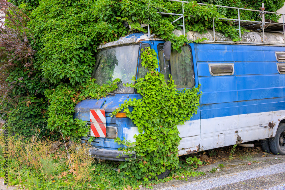 Von Efeu verschlungenes altes, verlassenes Wohnmobil Von Efeu verschlungenes altes, verlassenes Wohnmobil