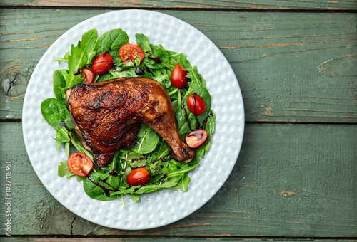 Grilled chicken legs with tomatoes and salad . Top view