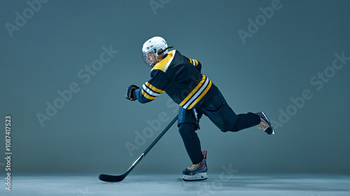 Canvas Print Competitive man, hockey player in full hockey uniform, in motion with stick, playing on studio ice rink