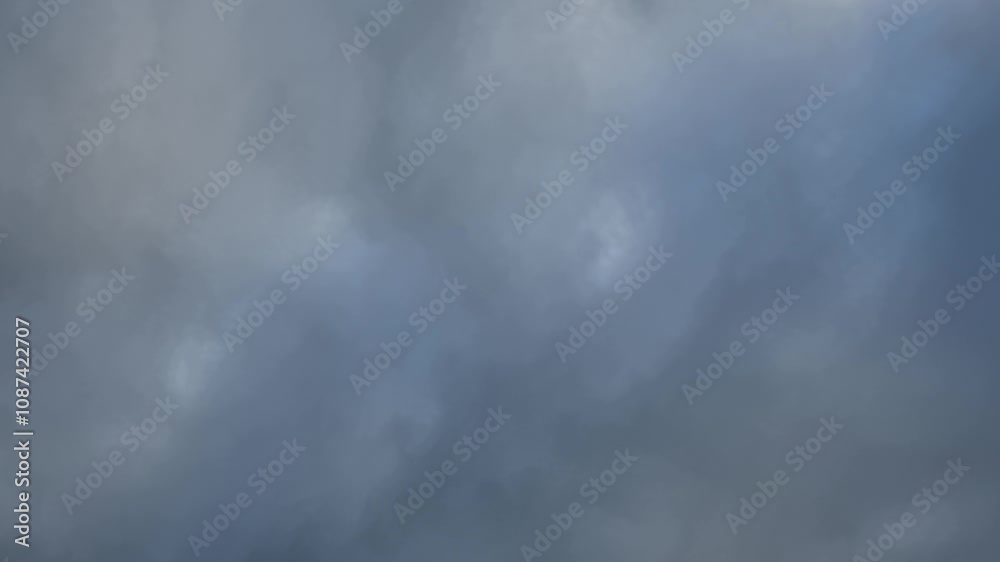 Time lapse looking up at a blue-gray sky full of winter storm clouds. On sky shown
Time lapse looking up at a blue-gray sky full of winter storm clouds. On sky shown