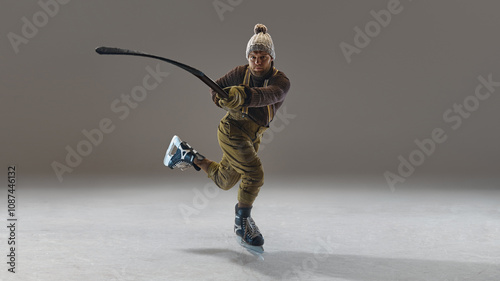 Photography Man wearing pants with suspenders, knitted warm sweater and hat, in motion with stick, hitting puck