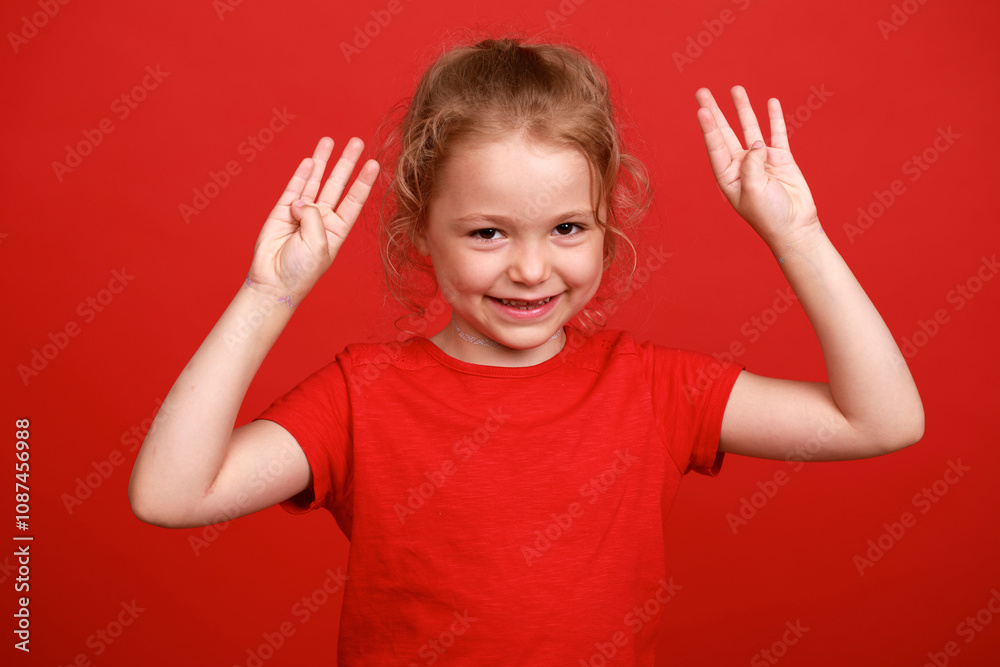 Beautiful blonde little girl, isolated on red studio background Beautiful blonde little girl, isolated on red studio background